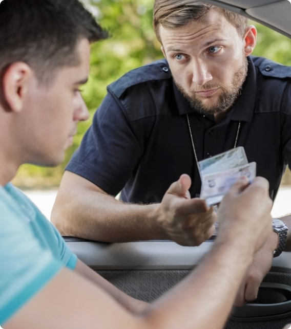 Driver handing license to an officer during a traffic stop