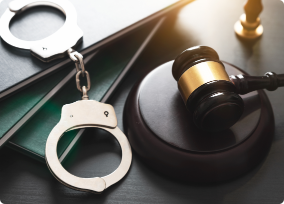 Handcuffs and a judge's gavel on a desk